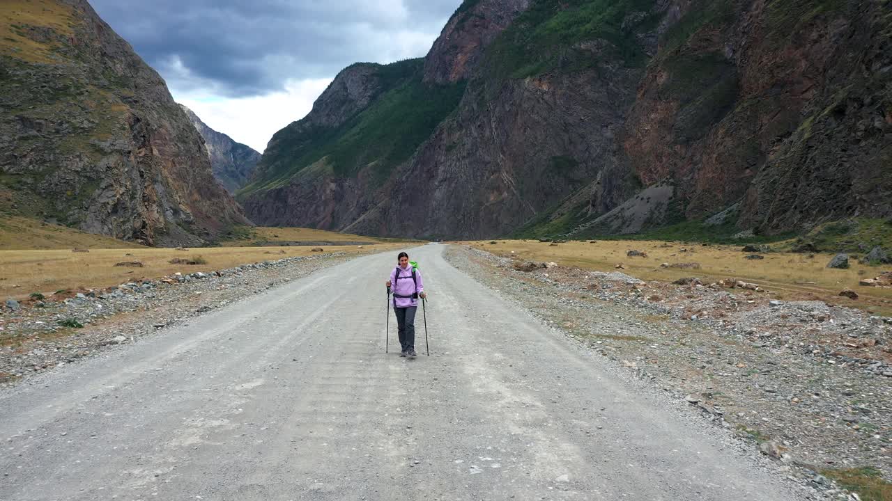 背着背包在国家公园山上的土路上徒步旅行的女游客视频素材