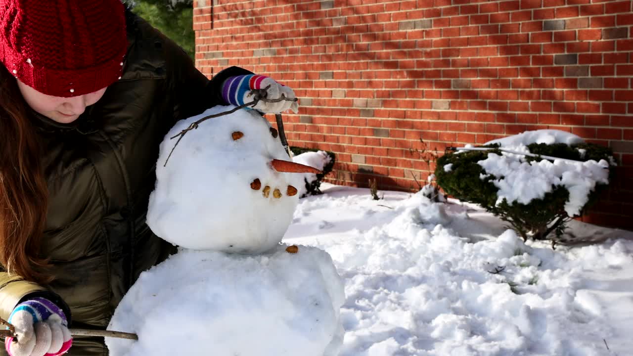 圣诞季快乐的孩子们在公园的雪地上雕刻一个雪人视频素材