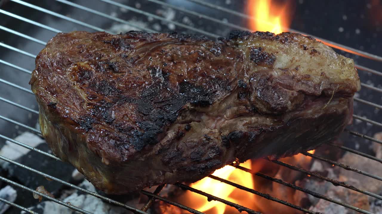 肋眼牛排牛肉烧烤与黄油和大蒜在火焰，牛肉牛排在烧烤与火焰。视频素材