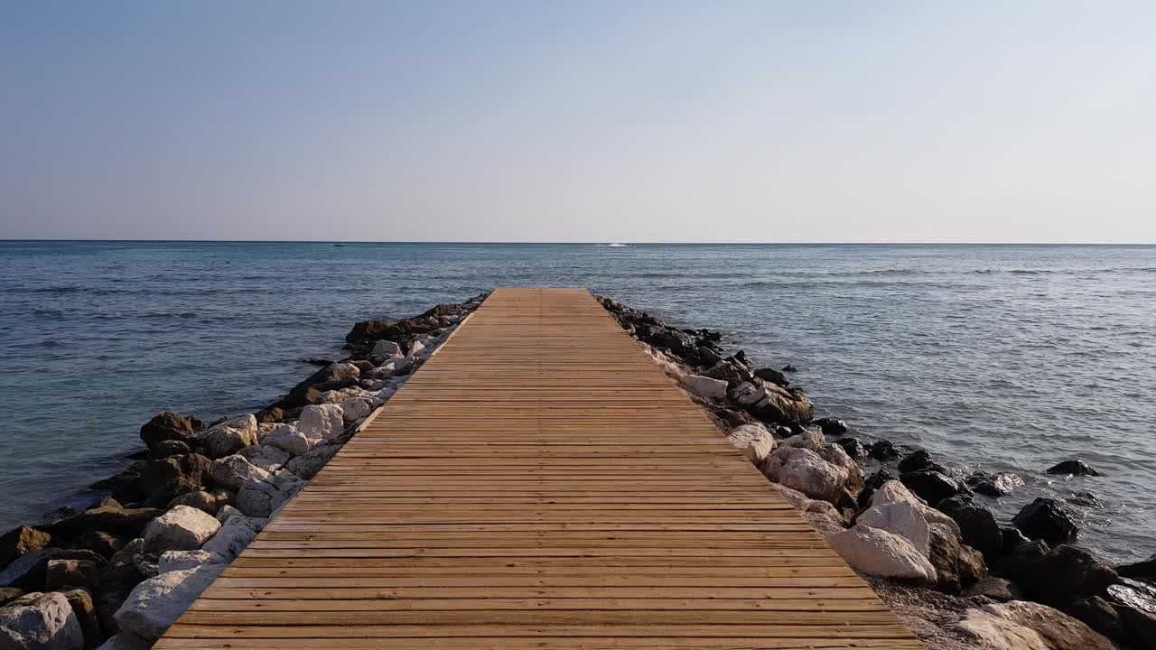 用石头加固的木墩。大海平静，天空湛蓝。旅游旺季。视频素材