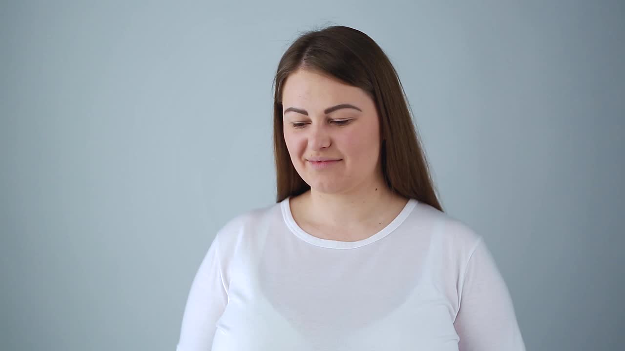 超重的年轻女人带着幸福的微笑。友好的大尺寸模型为视频剪辑在工作室视频素材