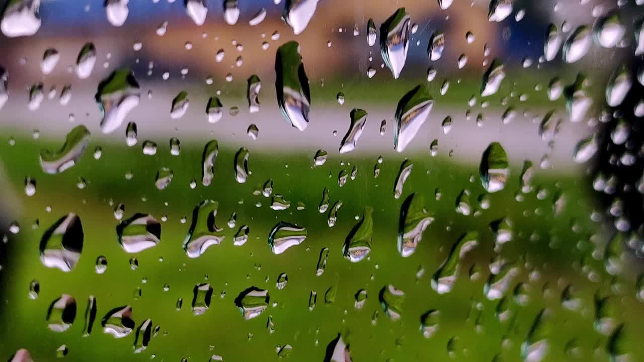 雨点落在路上的车窗玻璃上。模糊汽车在下雨天沿路行驶视频素材