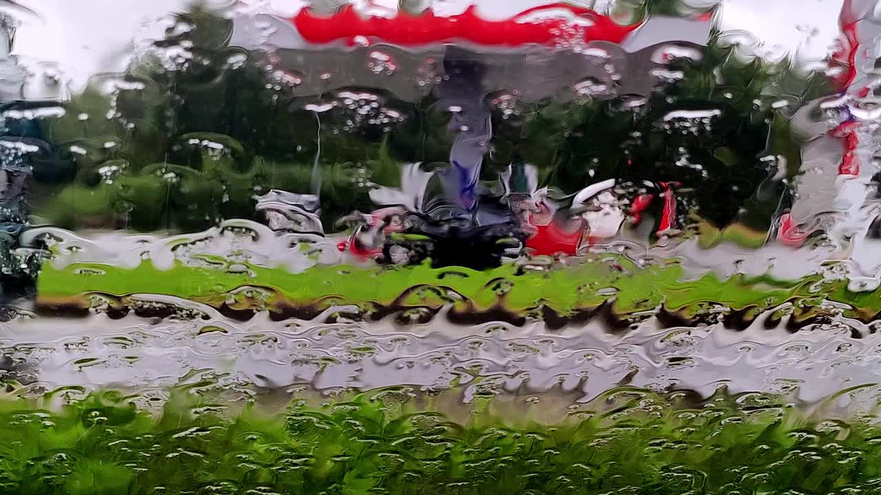 雨点落在路上的车窗玻璃上。模糊汽车在下雨天沿路行驶视频素材