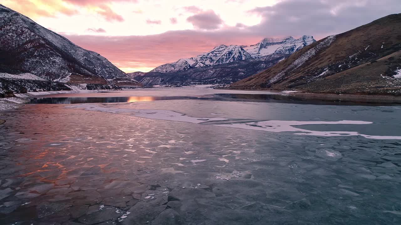 飞过冬日的风景，朝着夕阳下的雪山飞去视频素材