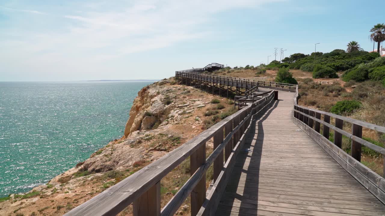 沿着木路散步，你会看到夏天葡萄牙卡沃埃罗海岸的美妙景色。俯瞰蓝色的大海。用稳定器在运动中射击。视频素材