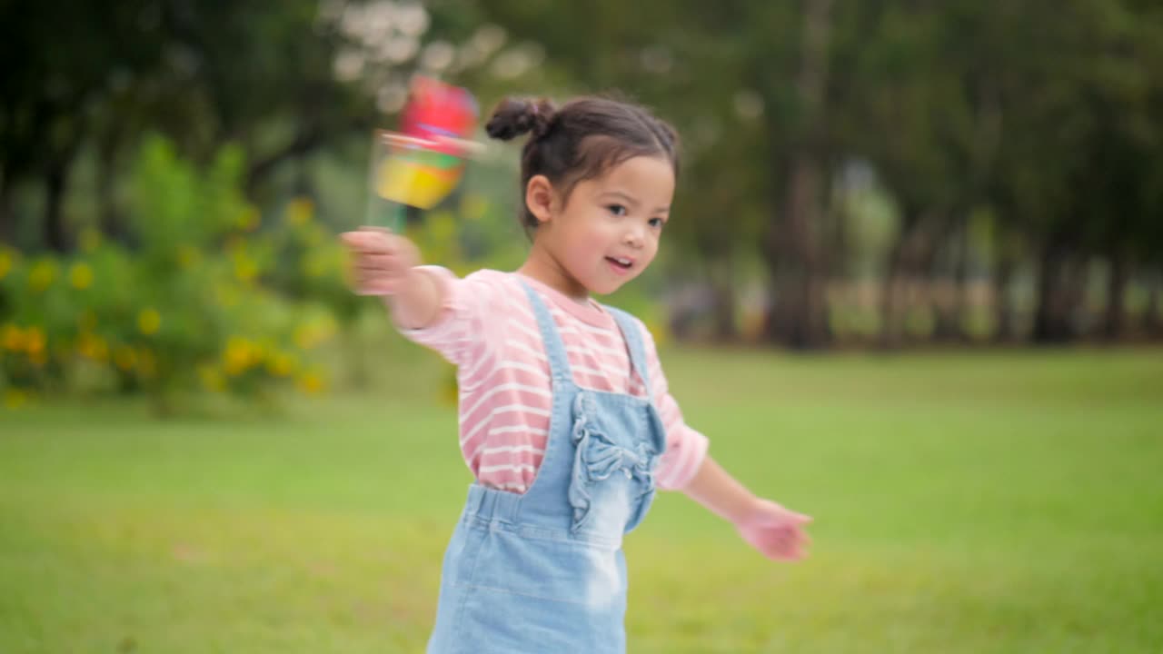 小女孩在玩纸风车视频素材