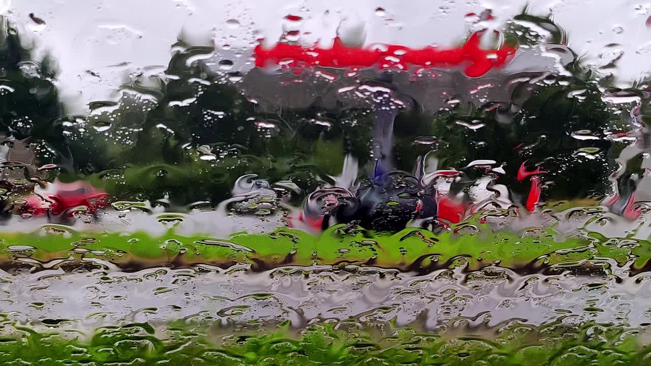 雨点落在路上的车窗玻璃上。模糊汽车在下雨天沿路行驶视频素材