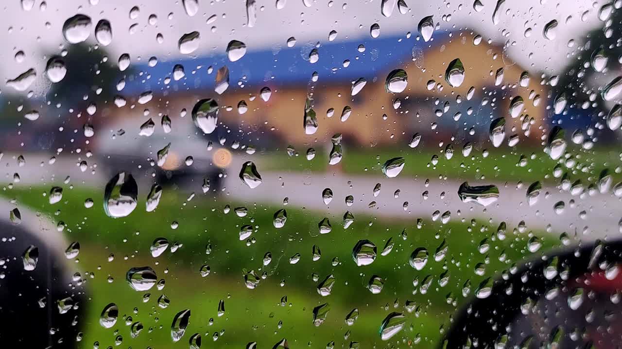 雨点落在路上的车窗玻璃上。模糊汽车在下雨天沿路行驶视频素材