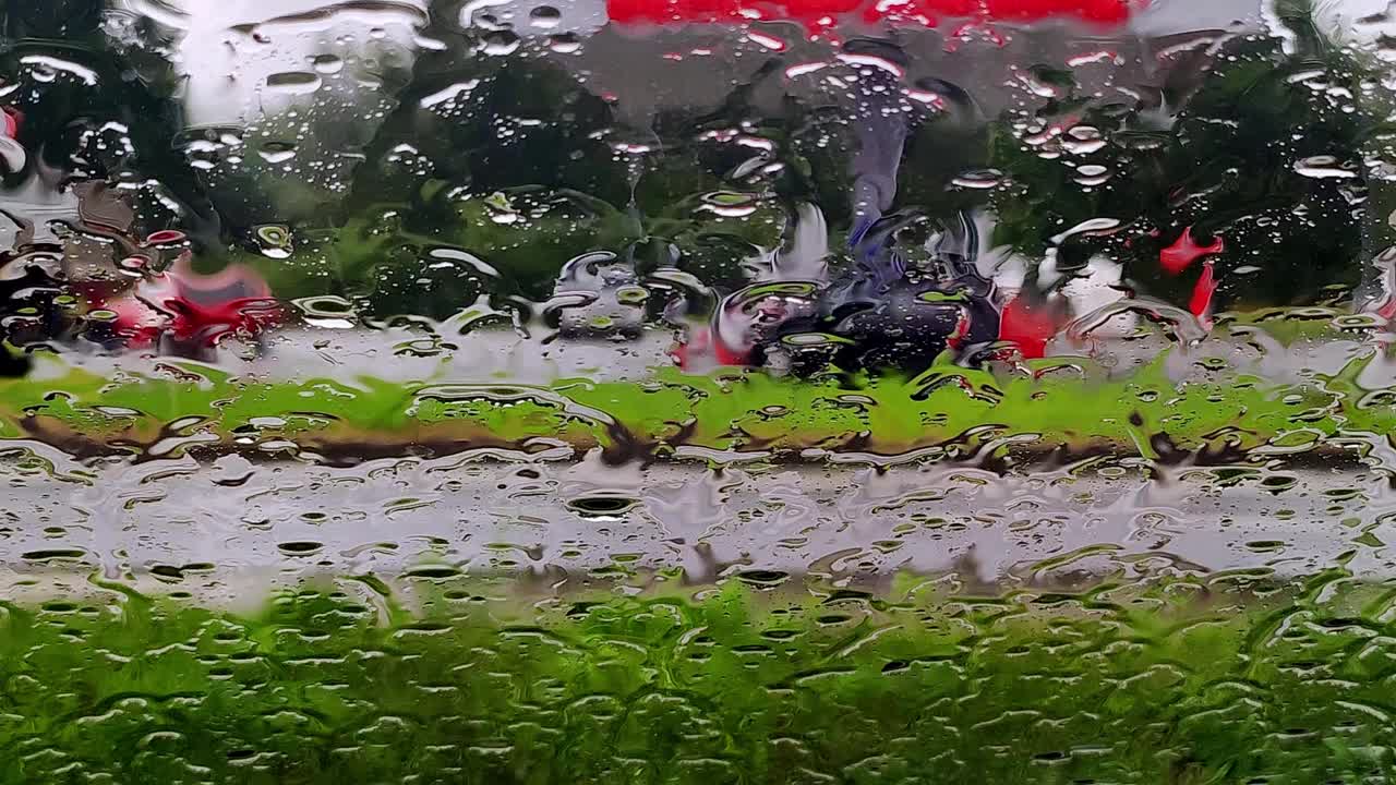 雨点落在路上的车窗玻璃上。模糊汽车在下雨天沿路行驶视频素材