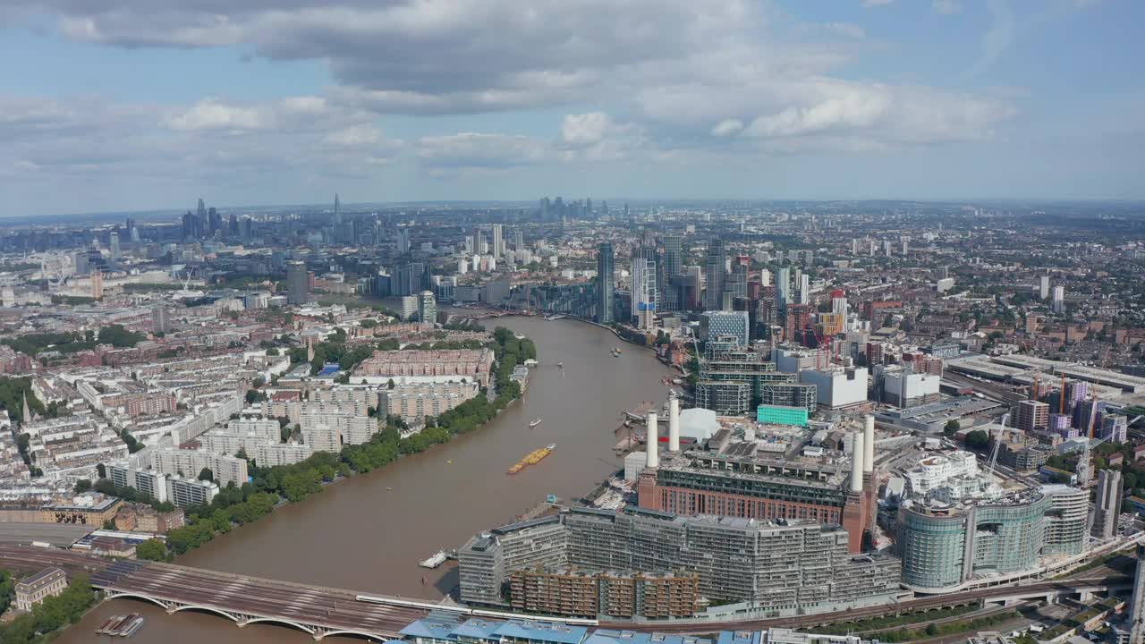 泰晤士河岸边的巴特西发电厂(Battersea Power Station)和附近的现代公寓楼。首都鸟瞰图。英国伦敦视频素材