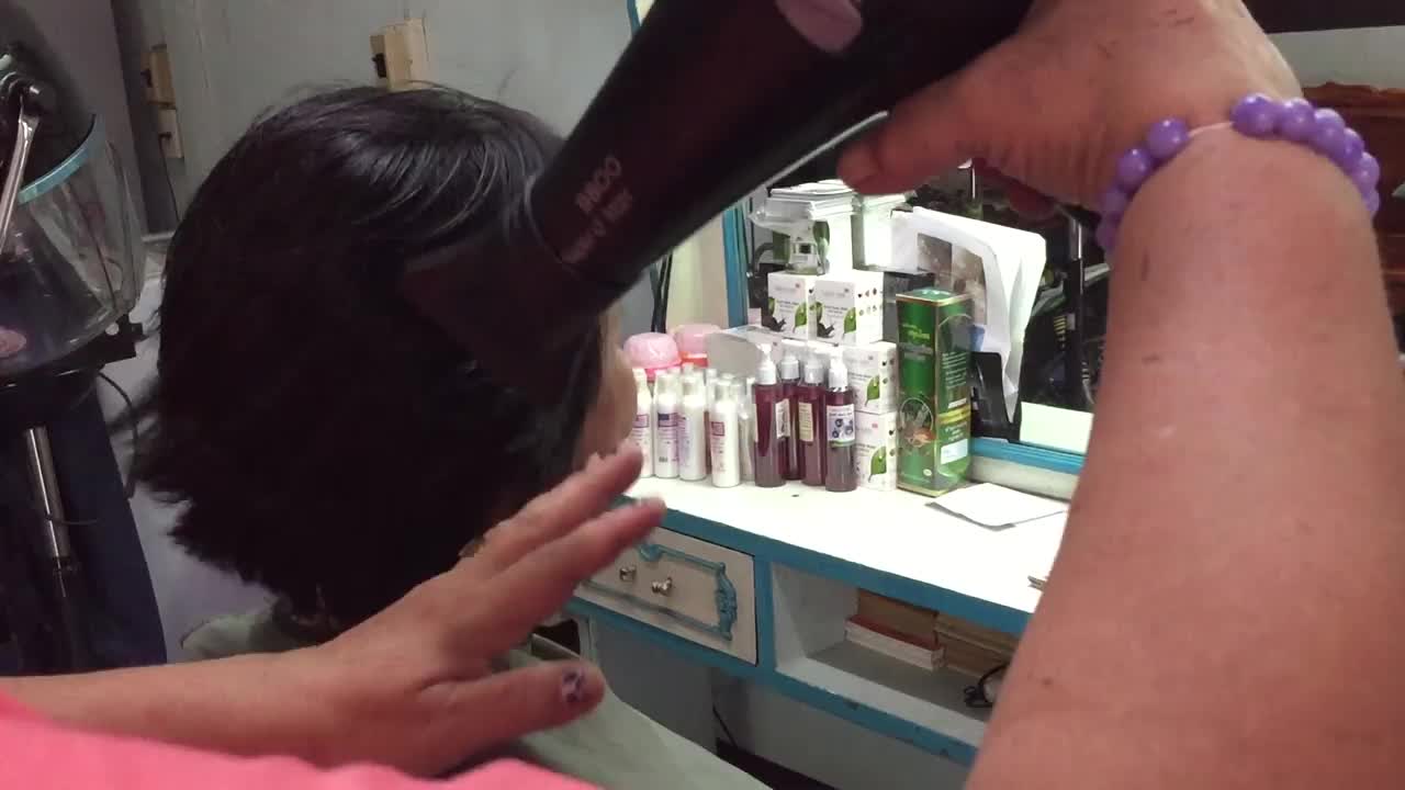 美发师给女士吹干头发视频素材