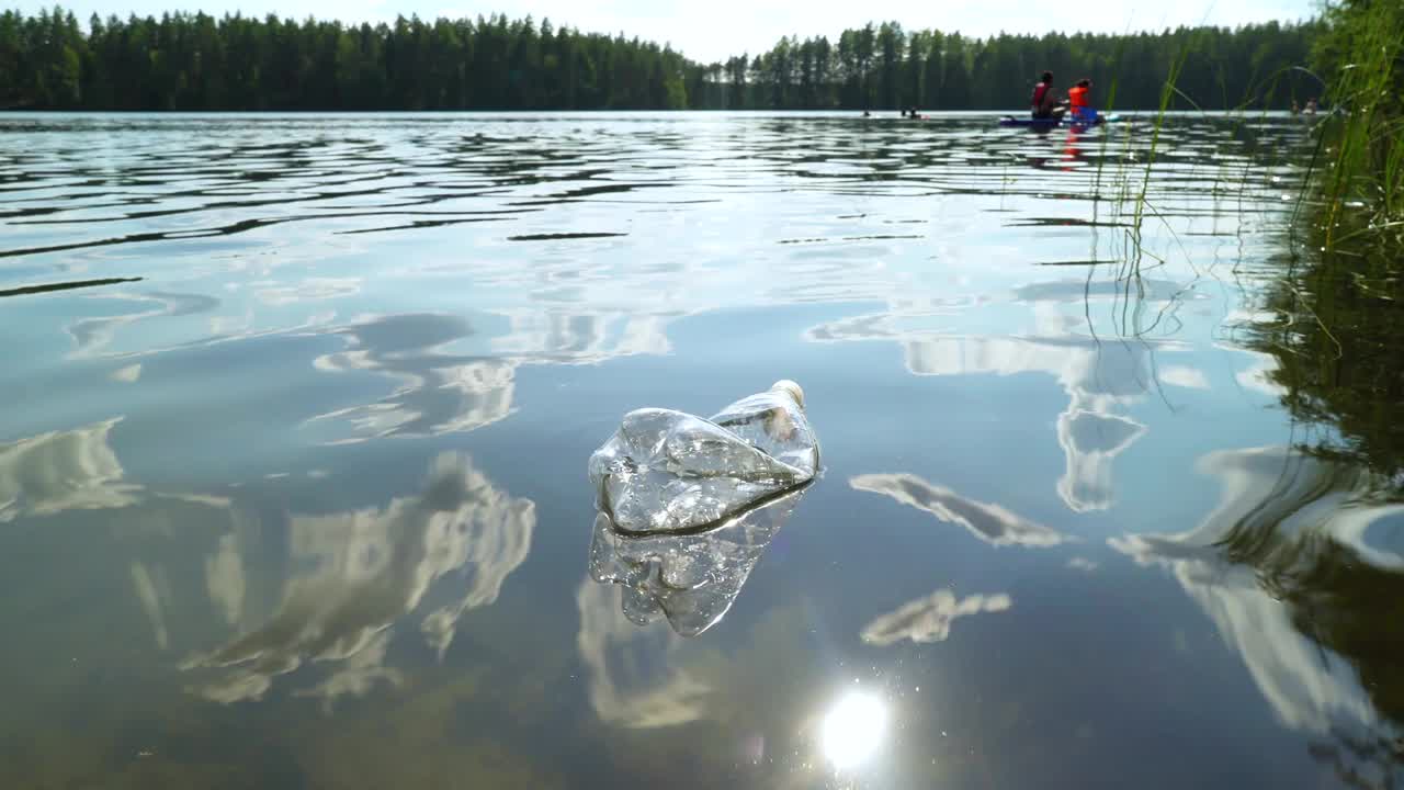 自然界中的塑料垃圾。用过的瓶子漂浮在水面上视频素材