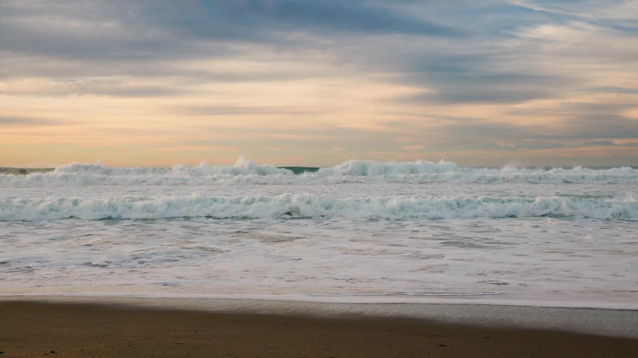 海滩上的日落。空旷的沙滩，绿松石色的海水，多云的天空，美丽而宁静的景象视频素材