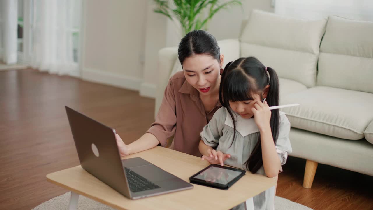 妈妈在家里用笔记本电脑帮助女儿学习视频素材