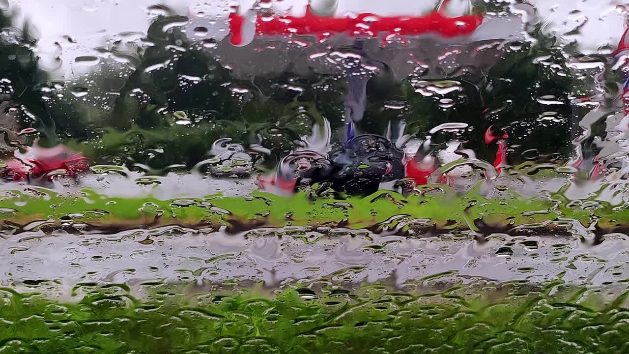 雨点落在路上的车窗玻璃上。模糊汽车在下雨天沿路行驶视频素材