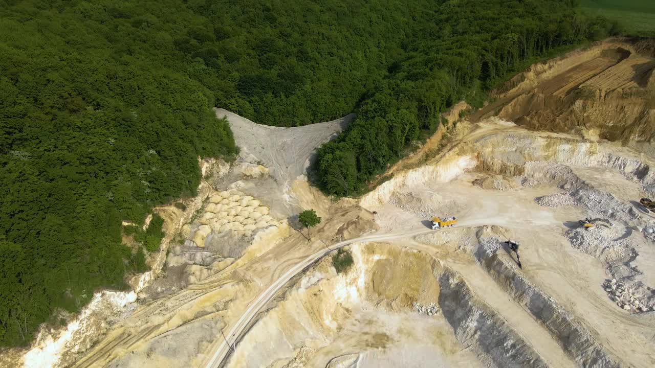 露天开采建筑砂石材料用挖掘机和自卸卡车。视频素材