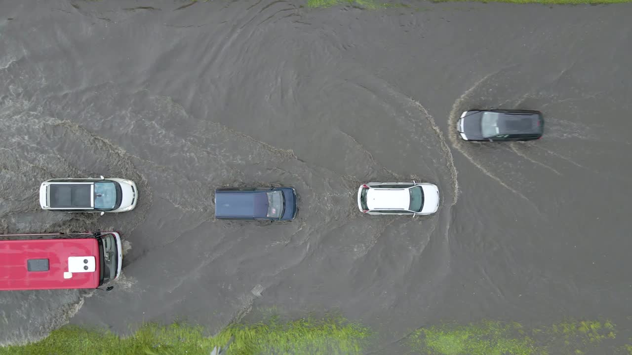 鸟瞰图的城市交通与汽车行驶在洪水后的街道。道路排水系统问题。视频素材