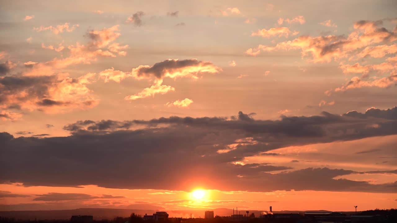 夕阳在一个小镇的郊区流逝，天空中飘动的云朵和蓝绿色的橙色调。放大效应视频素材