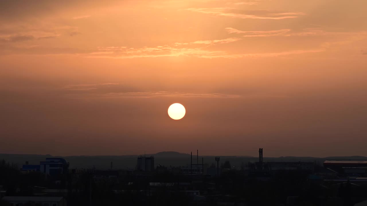 夕阳在一个小镇的郊区流逝，天空中飘动的云朵和蓝绿色的橙色调。放大效应视频素材