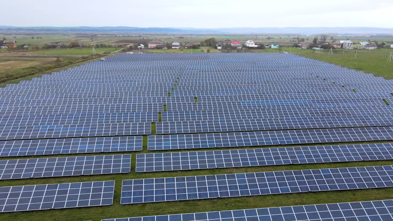 绿地上太阳能发电厂鸟瞰图。生产清洁生态能源的电板。视频素材