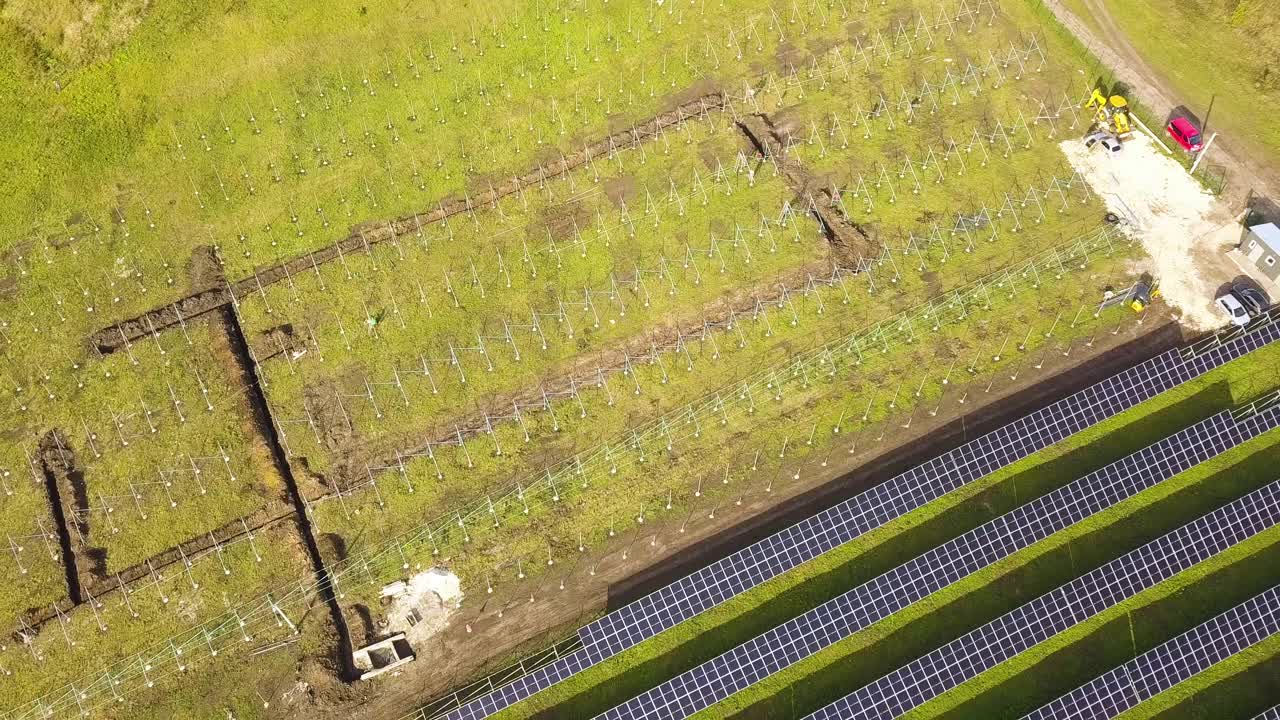 绿地上正在建设的太阳能发电厂鸟瞰图。生产清洁生态能源的电板组装。视频素材