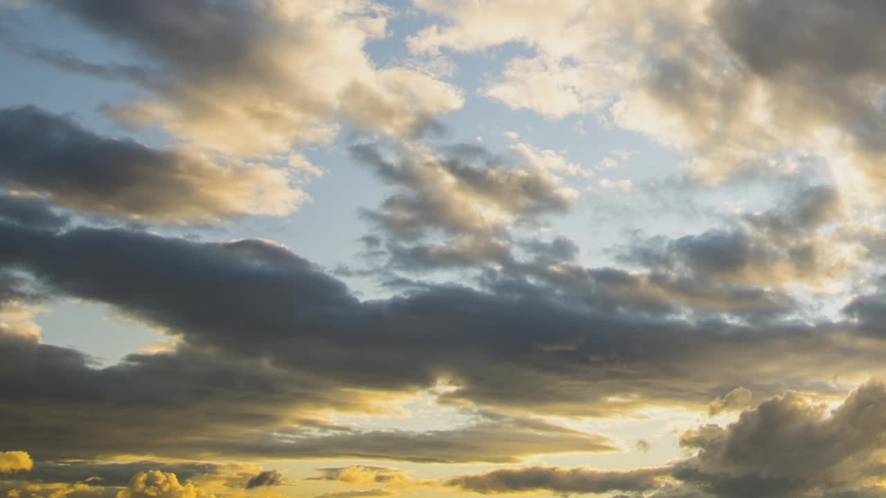 日落时深蓝色天空上快速移动的云的时间流逝。视频素材