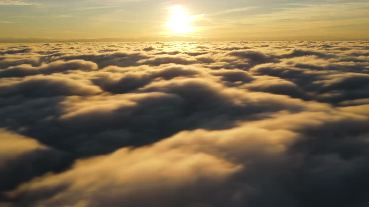 鸟瞰图，充满活力的黄色日出在白色浓密的云和蓝色的天空。视频素材