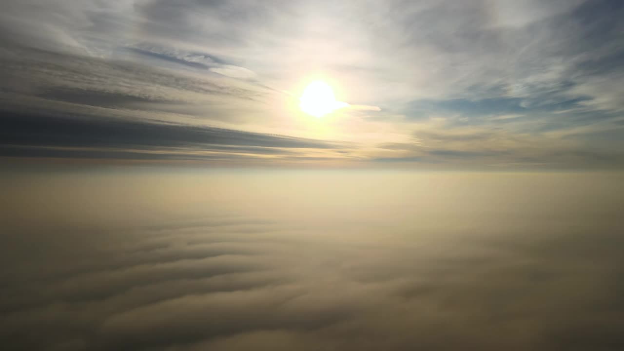 鸟瞰图明亮的黄色日落在白色浓密的云与蓝色的天空。视频素材