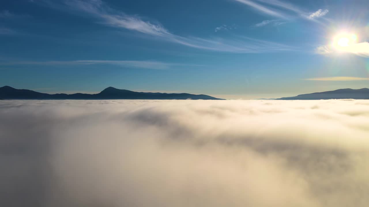 鸟瞰图向前移动在白色的浮云在宽阔的山谷。视频素材