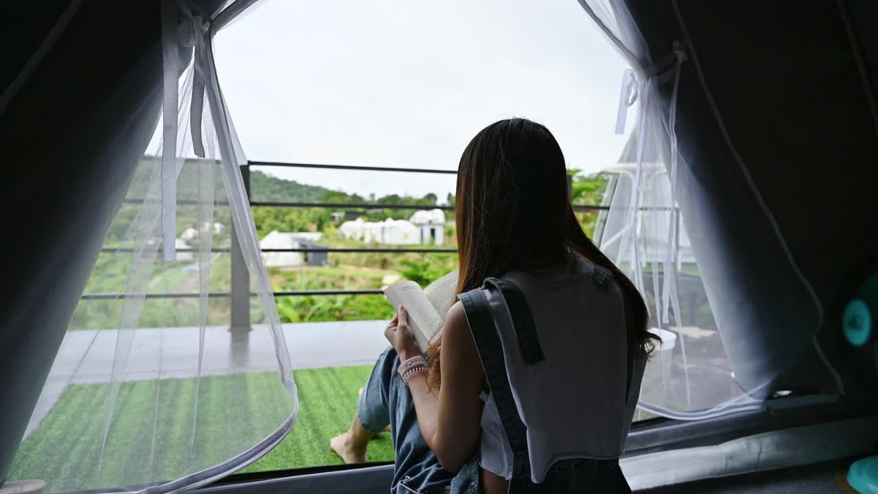 雨天，亚洲女人从帐篷里走出来，走到阳台上欣赏大自然视频素材