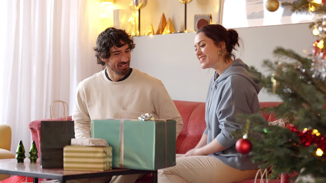 幸福的夫妇在家里交换圣诞礼物视频素材