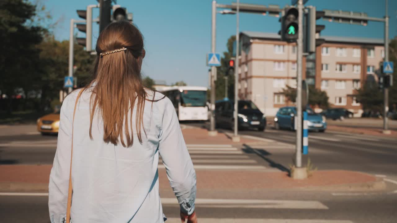 一个女人正在城市里过马路。视频素材