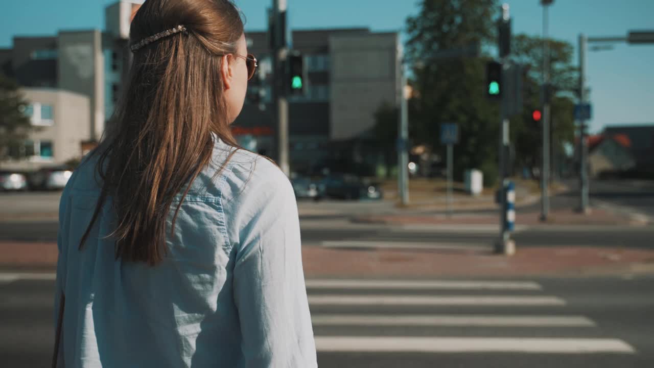 一个女人正在城市里过马路。视频素材