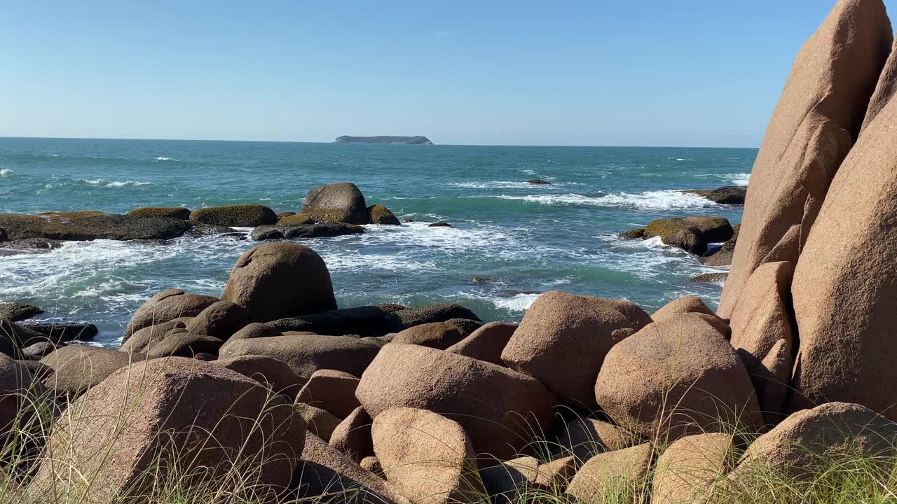 在阳光明媚的日子里，在空旷的海滩上欣赏美丽的海浪和沙滩。视频素材