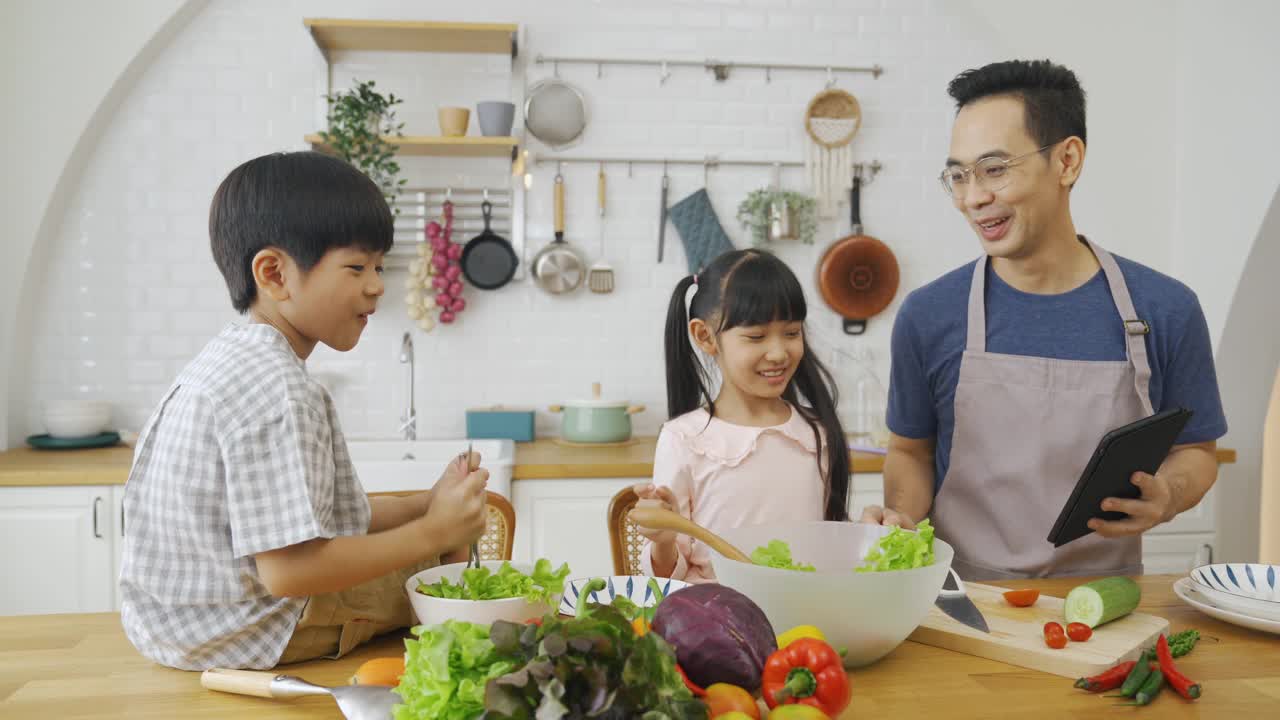 亚洲家庭用平板电脑做沙拉视频素材