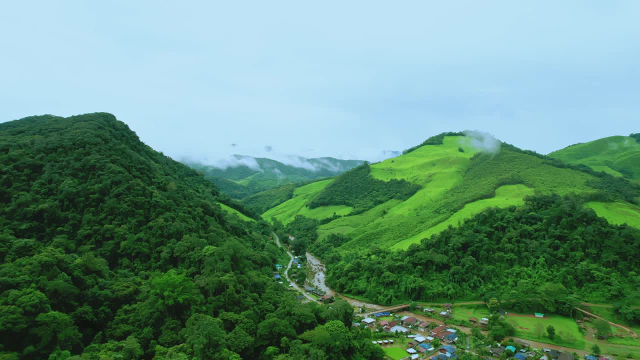 鸟瞰无人机拍摄的流动的雾波在山区热带雨林在晚上，鸟瞰图像在云上惊人的自然背景与云和山峰。视频素材