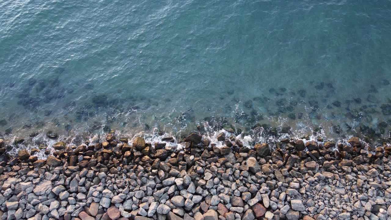 海岸上的石头冲刷着蓝色的大海视频素材