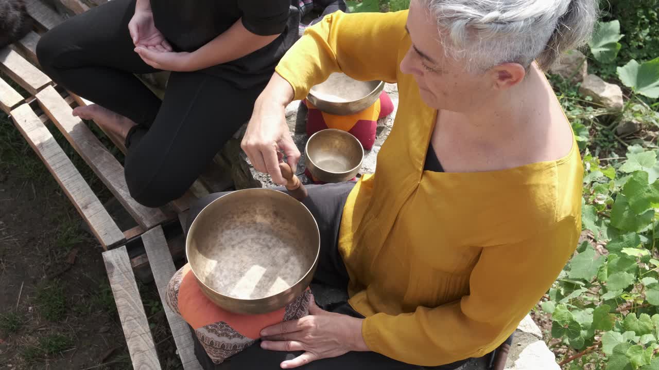 俯视图，一个成熟的女人正在演奏一个西藏的唱盘，诱导冥想。视频素材