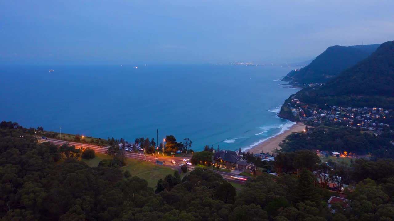 空中时间流逝潘:黄昏海边的山附近的城市景观视频素材