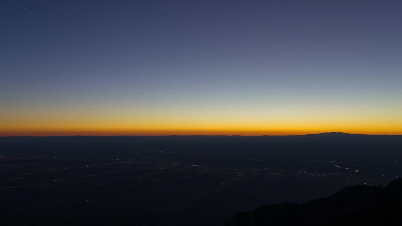 当月亮和星星向下移动时，金色照明城市的空中封锁风景-阿尔伯克基，新墨西哥州视频素材