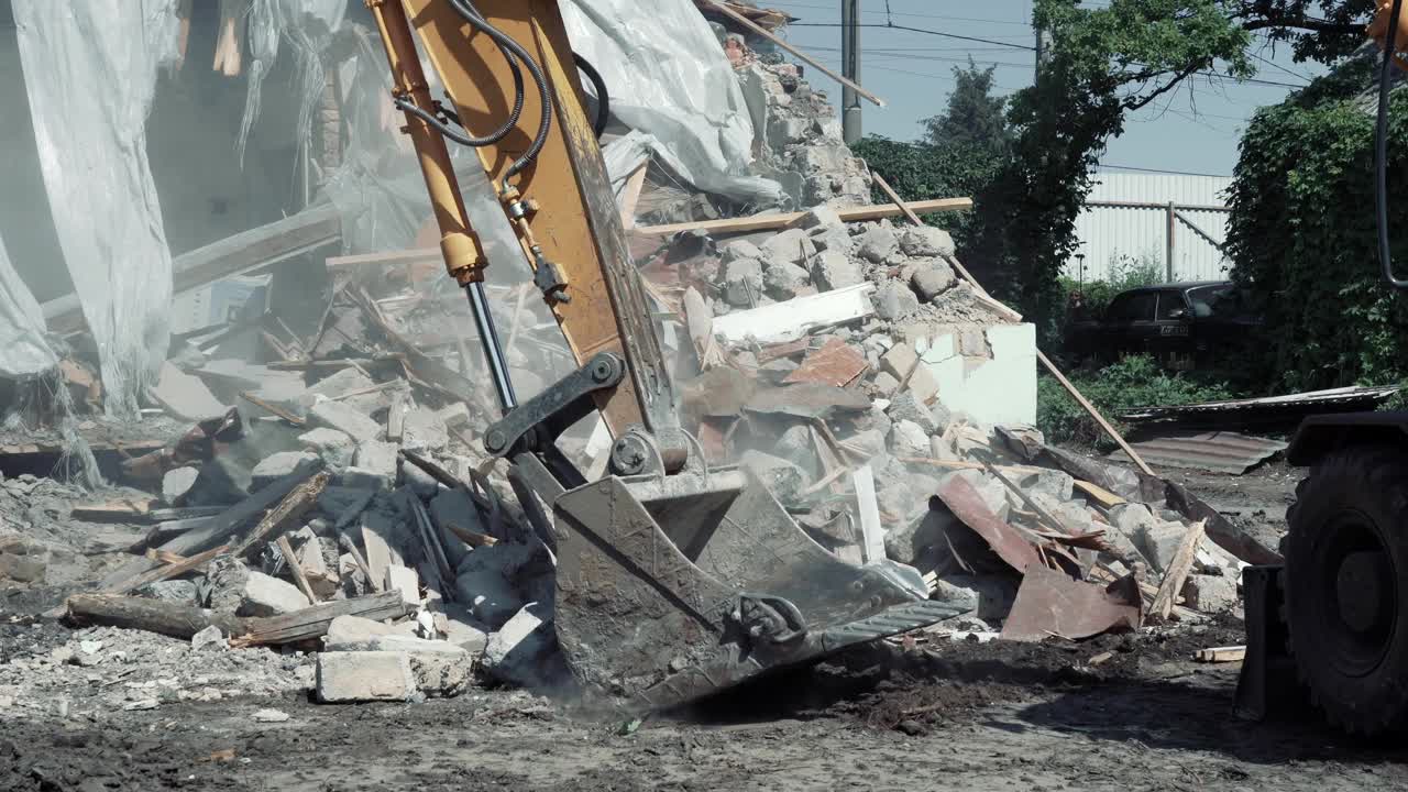 拆除建筑物。挖掘机破坏旧房子。腾出空间建造新建筑视频素材