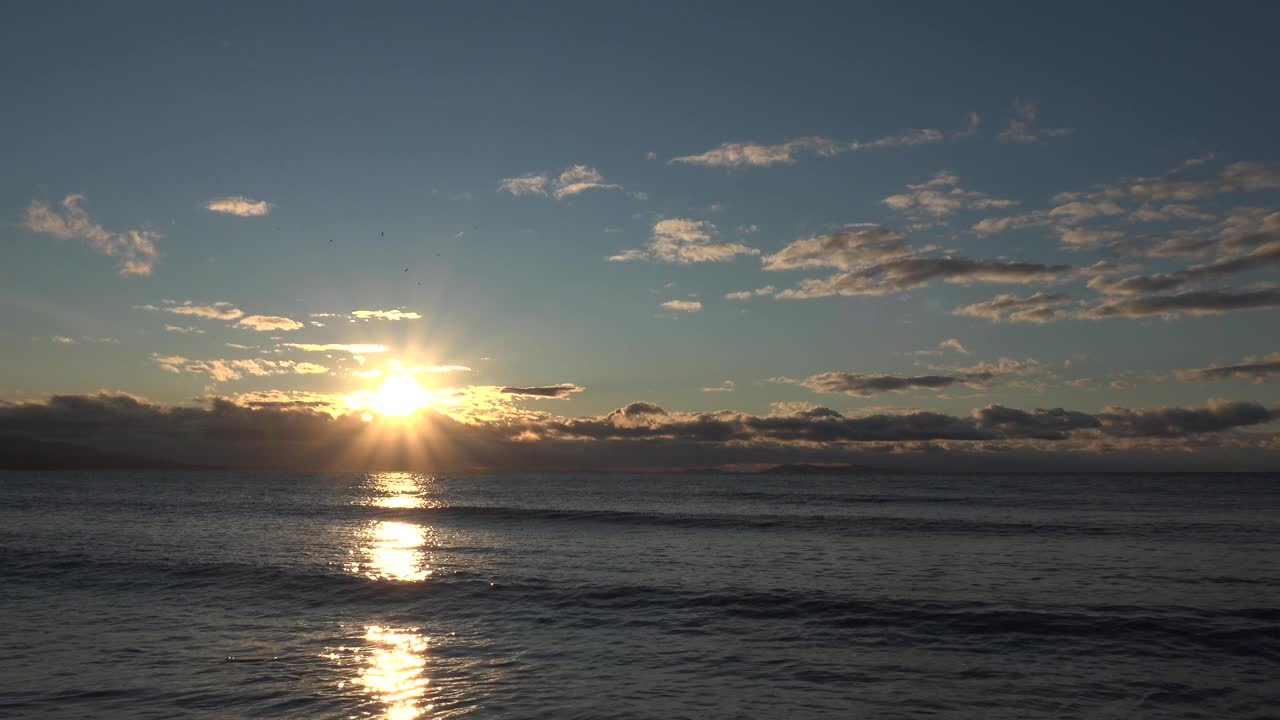 美丽的日落，海面上有云朵和亮光视频素材