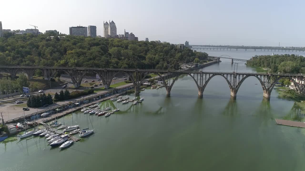 在一个大城市的河上架桥。在一个大城市的河面上的铁路桥附近飞行。铁路桥横跨河上。视频素材