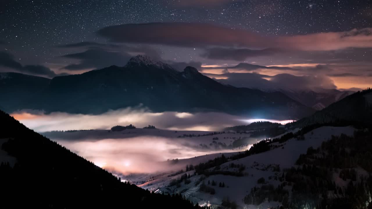 神奇的夜空和星星运动在冬季阿尔卑斯山山脉在雾谷自然天文学时间流逝视频素材