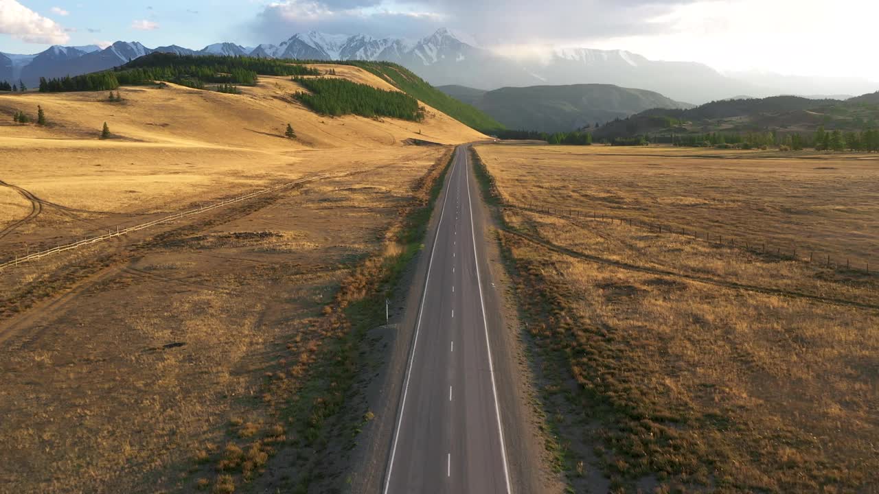 空沥青公路通过沙漠到雪山鸟瞰图视频素材