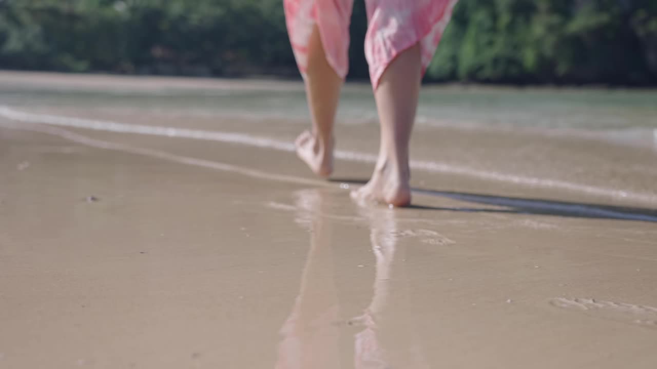 模糊拍摄的女性光脚行走在细细的沙滩上，享受海浪拍打脚，炎热的阳光天气，清澈的海水，清新的旅行，南印度洋，安达曼海岛跳跃视频素材