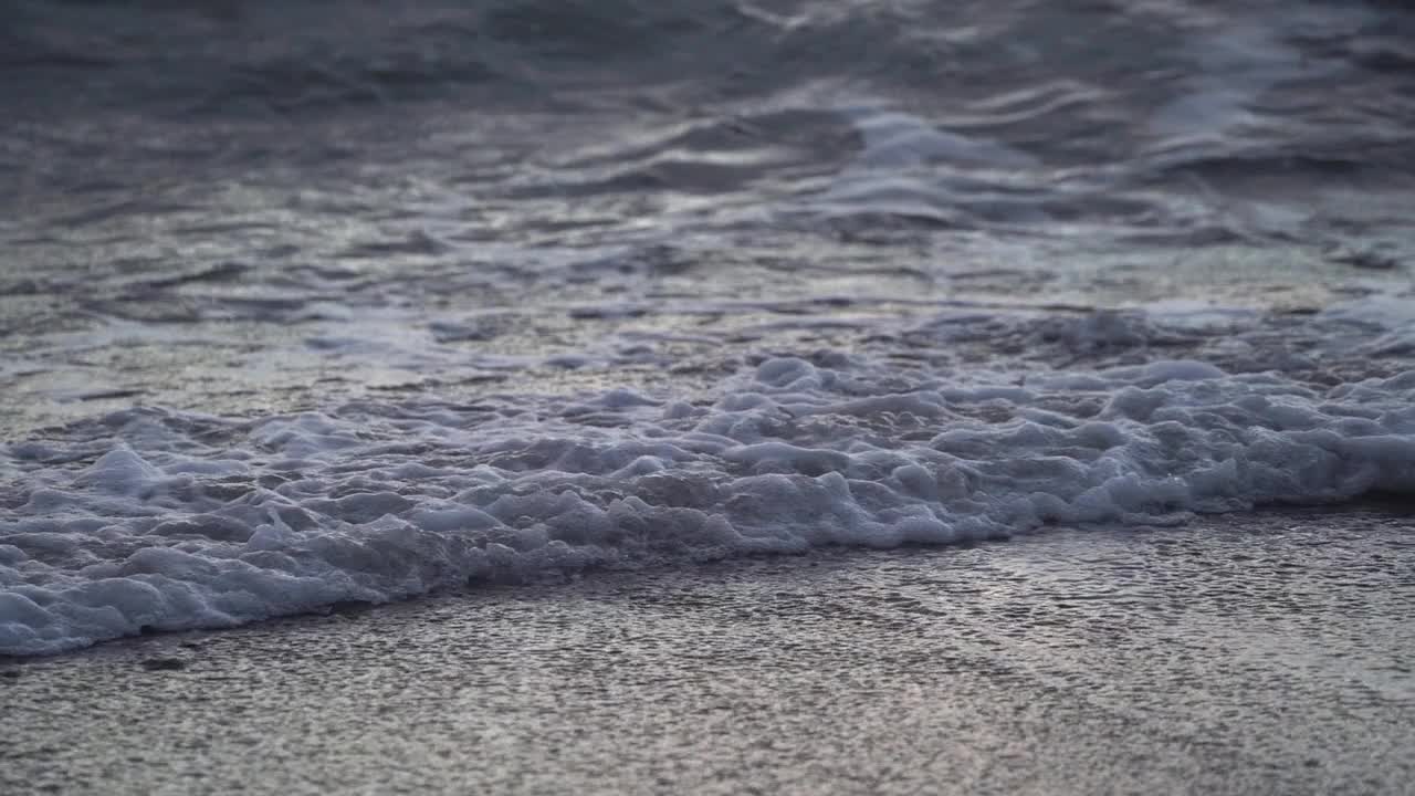 带着白色泡沫的狂暴海浪在卵石滩上翻滚。视频下载