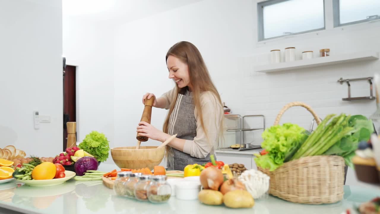 女人在厨房做饭很开心。视频素材