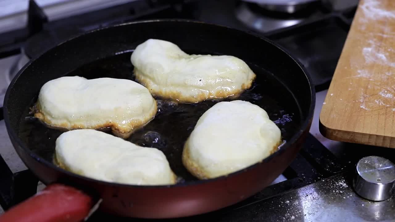 用土豆填充的馅饼，女人的手放在煎锅里滚烫的油里视频素材