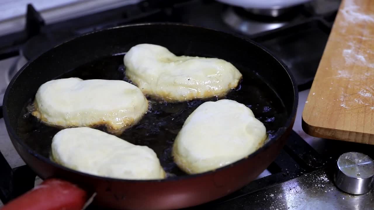 用土豆填充的馅饼，女人的手放在煎锅里滚烫的油里视频素材